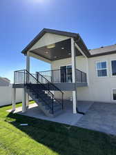 Rear view of house featuring a lawn and a patio area