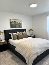 Carpeted bedroom featuring a textured ceiling