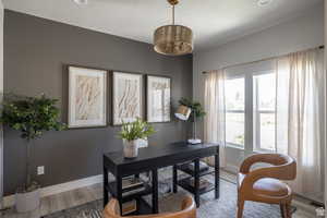 Home office featuring a textured ceiling, a chandelier, and hardwood / wood-style flooring