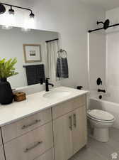 Full bathroom featuring shower / tub combo, vanity, tile patterned flooring, and toilet