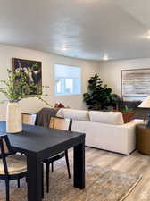 Dining space featuring light wood-type flooring and a textured ceiling