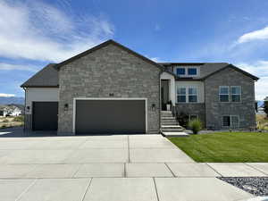 View of front of property featuring a front yard and a garage