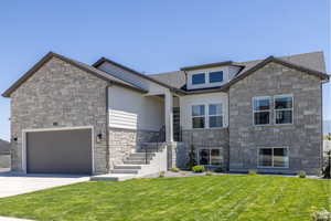 View of front of house with a front lawn and a garage