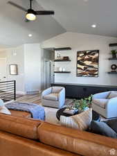 Living room with ceiling fan, wood-type flooring, and vaulted ceiling