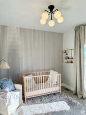 Bedroom featuring carpet flooring and a crib