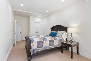 Bedroom with light carpet and a closet