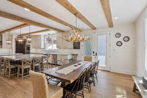 Dining space with beamed ceiling, french doors, plenty of natural light, and light hardwood / wood-style floors