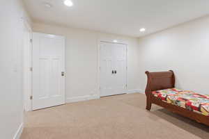 Bedroom with light carpet and a closet