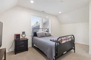 Carpeted bedroom with lofted ceiling