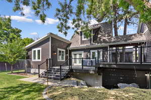 Back of property with a wooden deck and a lawn