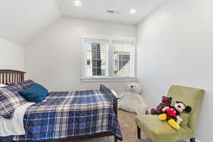 Guest house carpeted bedroom with lofted ceiling