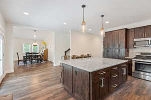 Guest house kitchen featuring appliances with stainless steel finishes, dark hardwood / wood-style floors, and a kitchen island