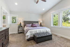 Guest house carpeted bedroom featuring ceiling fan and vaulted ceiling