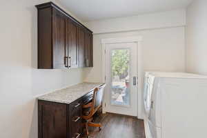 Guest house laundry room featuring washing machine and clothes dryer, cabinets, and dark hardwood / wood-style flooring