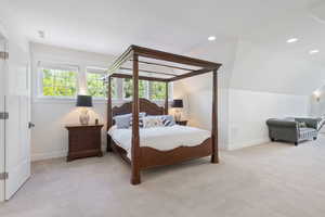 Bedroom with vaulted ceiling and light colored carpet