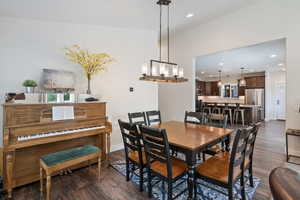 Guest house dining room with dark hardwood / wood-style floors and an inviting chandelier