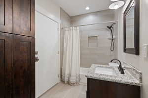 Guest house bathroom featuring shower / bathtub combination with curtain, vanity, and tile patterned flooring