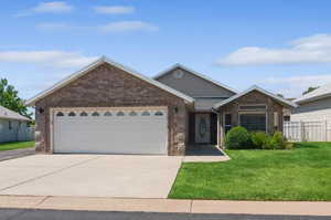 Ranch-style house featuring a garage and a front yard