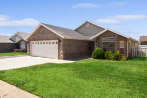 Ranch-style home with a front lawn and a garage