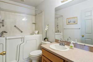 Full bathroom featuring tiled shower / bath combo, vanity, and toilet