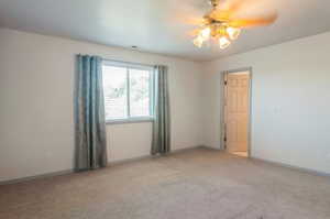 Spare room featuring light carpet and ceiling fan