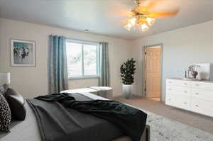 Carpeted bedroom featuring ceiling fan