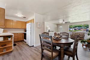 Dining area with ceiling fan and light hardwood / wood-style flooring