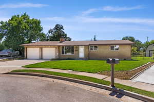 Ranch-style home featuring a garage and a front yard