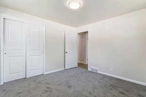 Unfurnished bedroom with a closet and carpet