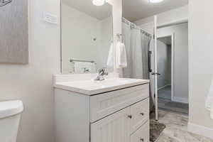 Bathroom with toilet, vanity, large shower and tile floor