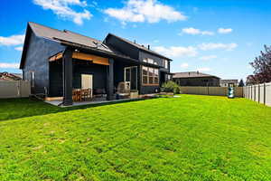 Rear view of property with a patio and a yard