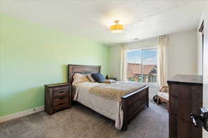 Bedroom with a textured ceiling and light colored carpet