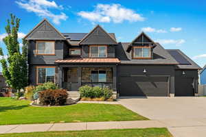 Craftsman-style home featuring a front yard and a garage