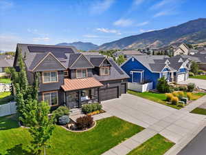 View of front of property featuring a front lawn, a mountain view, and a garage