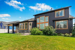 Back of house with a patio and a yard