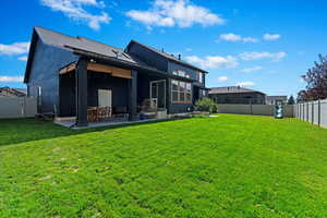 Rear view of house with a patio area and a yard