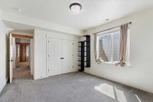 Unfurnished bedroom featuring carpet and a closet