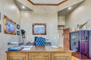 Office with crown molding and light hardwood floors