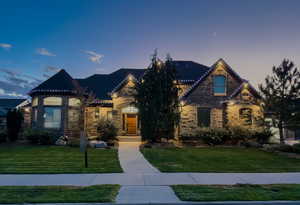 Permanent Holiday lights and eve can lights. View of front of home featuring a lawn