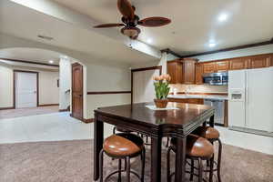 Kitchen with light carpet, crown molding, stainless steel appliances, ceiling fan, and sink