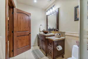 Bathroom with tile patterned floors, vanity, and toilet