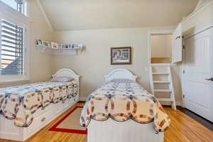 Bedroom featuring light hardwood  flooring and vaulted ceiling, and a cute hidden play room.