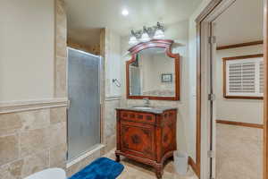 Bathroom featuring tile walls, an enclosed shower, ornamental molding, tile patterned floors, and vanity