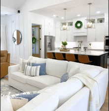 Living room featuring a notable chandelier, light hardwood / wood-style flooring, and vaulted ceiling