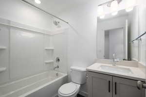 Full bathroom with shower / bath combination, vanity, and toilet