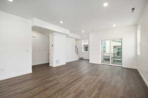 Unfurnished living room featuring dark wood-type flooring