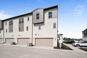 View of building exterior featuring central air condition unit and a garage