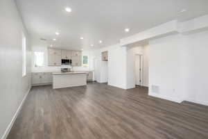 Unfurnished living room featuring dark wood-type flooring