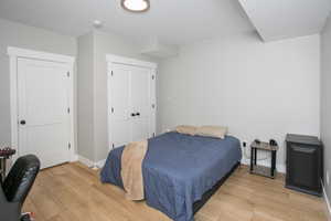 Bedroom with light hardwood / wood-style floors and a closet