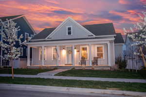 View of front facade featuring a lawn and covered porch